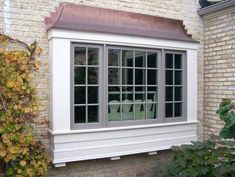 a white window sitting next to a brick building