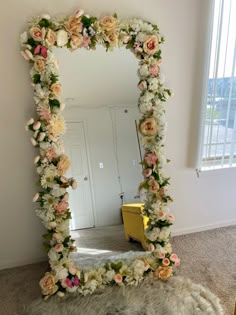 a mirror that has flowers on it in the middle of a room next to a rug