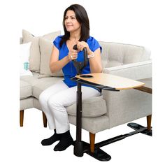 a woman sitting at a table with a remote control in her hand and holding a mouse