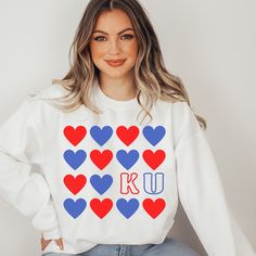 Calling all Kansas fan girls! Show your love for KU basketball with this darling 'heart ku' crewneck sweatshirt. Perfect for gameday at Allen Fieldhouse.  DETAILS *Unisex Premium Crewneck Sweatshirt * Soft & lightweight * 100% combed and ring-spun cotton (heather colors contain polyester) * Design is printed using DTG technology which uses high-quality water-based inks that are printed directly into the fabric. SIZING * Runs true-to-size for unisex crewneck * Meant to be a bit loose fitting. If School Spirit Designs, High School Shirt Designs, Spiritwear Designs, Allen Fieldhouse, Spirit Wear Designs, School Spirit Shirts Designs, Ku Basketball, Team Spirit Shirts, Cheer Gear