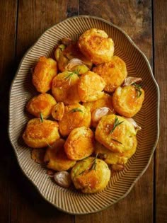 a bowl filled with potatoes and onions on top of a wooden table