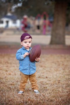 a little boy holding a football in his hands