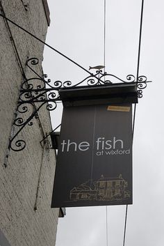 a sign hanging from the side of a building that says the fish on ward road