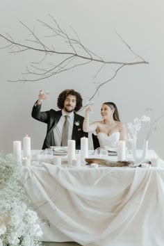 a man and woman sitting at a table with candles