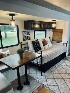 a living room filled with furniture and lots of windows in the back wall, next to a dining table