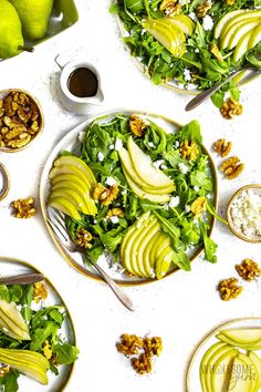 a table topped with plates and bowls filled with food next to pears, walnuts and apples