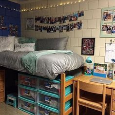 a dorm room with a bed, desk and storage bins on the bottom shelf