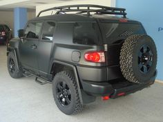 a black truck parked in a garage next to other cars