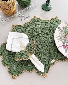 a table topped with plates and crocheted doily