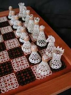 a wooden chess board with crocheted pieces on it