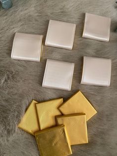 several pieces of white and gold paper sitting on top of a fur covered floor