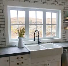 a white kitchen sink sitting under a window