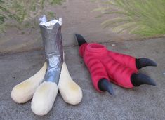 two stuffed animals laying on the ground next to each other with their feet wrapped in tin foil