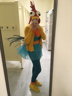 a woman taking a selfie in front of a mirror with a chicken costume on