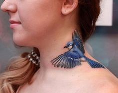 a woman with a blue bird tattoo on her neck