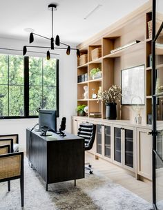 an office with lots of shelves and desks next to a large window that looks out onto the woods