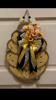 a door hanger decorated with flowers and bees