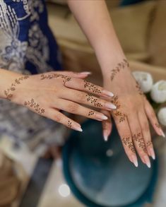 two hands with henna tattoos on them