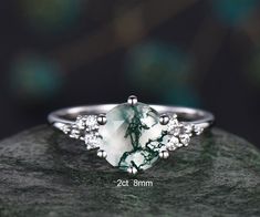 a green and white ring sitting on top of a rock