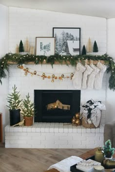 a fireplace decorated for christmas with stockings and garland