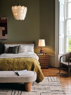 a bedroom with a large bed and two chairs next to each other in front of a window