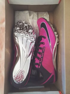 two pairs of pink and black shoes in a box