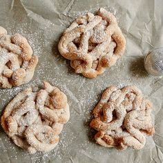 four powdered sugar covered cookies sitting on top of a table