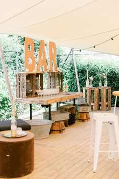 an outdoor bar set up with stools and tables