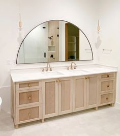 a bathroom with two sinks and a large mirror over the bathtub in front of it