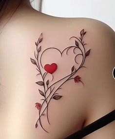 the back of a woman's shoulder with a heart and vines tattoo on it