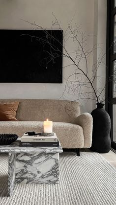 a living room with a marble coffee table and black vases on the wall next to it