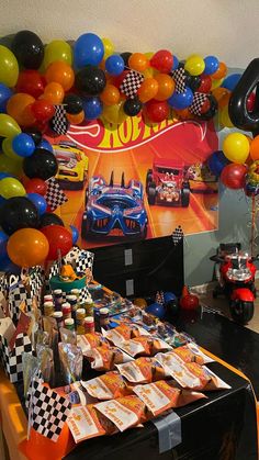 a birthday party with balloons and race cars on the wall, including an auto racing theme