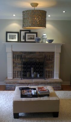 a living room with a fireplace and pictures on the mantel above it's mantle