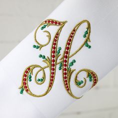 embroidered monogrammed napkin on white cloth with red and green accents