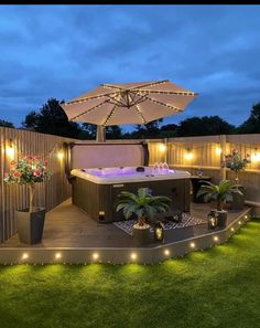 an outdoor hot tub with lights around it and potted plants on the ground next to it