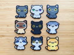 six pixelated cats sitting on top of a wooden table next to eachother