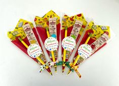 a bunch of yellow and red toothbrushes sitting next to each other on a white surface