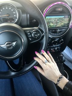 a woman's hand on the steering wheel of a car