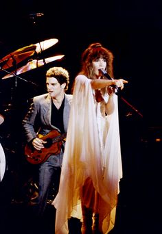 two people on stage with one holding a guitar