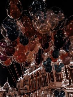 many balloons are floating in the air at night