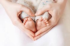 a woman holding two baby feet in her hands