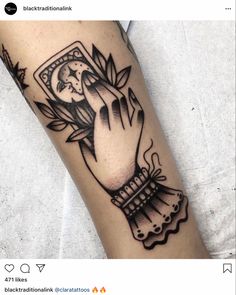 a black and white photo of a hand holding a clock with leaves on the wrist