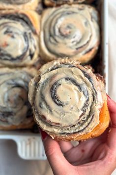 a person holding a pastry in their hand with some kind of swirl on top of it