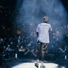 a man standing on top of a stage in front of a large group of people