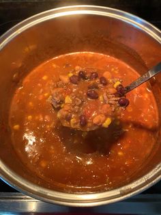 a ladle full of soup sitting on top of a stove