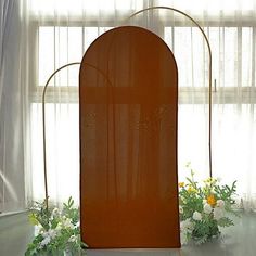 an orange screen sitting on top of a table next to white flowers and greenery