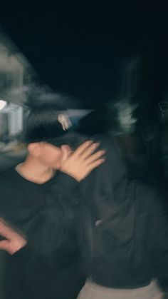 a blurry image of two people hugging each other