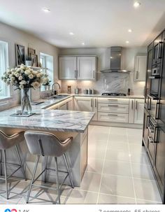 a kitchen with marble counter tops and stainless steel stools in front of an island