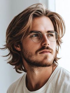 In this photo, the model’s shoulder-length hair is styled with soft waves, paired with glasses to create an intellectual, sophisticated look. His light brown hair frames his face gently, making his features stand out. This style is ideal for men who want a polished and studious appearance. I’ve styled similar looks for clients who appreciate a refined, cultured vibe. The waves add a touch of elegance and sophistication. Men Long Bangs Haircut, Long On Top Haircuts For Men, Chin Length Mens Haircut, Jaw Length Hair Men, Shoulder Length Hair Guys, Longer Hair Styles For Men, Medium Length Slick Back Hair Men, Long Haircut For Men With Thick Hair, Medium Length Hair For Men