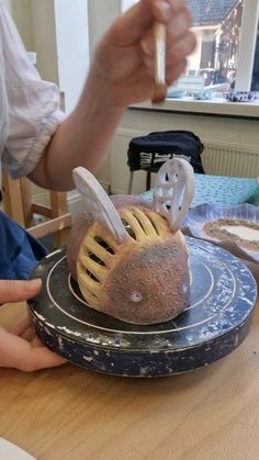 a person holding a knife and fork over some bread